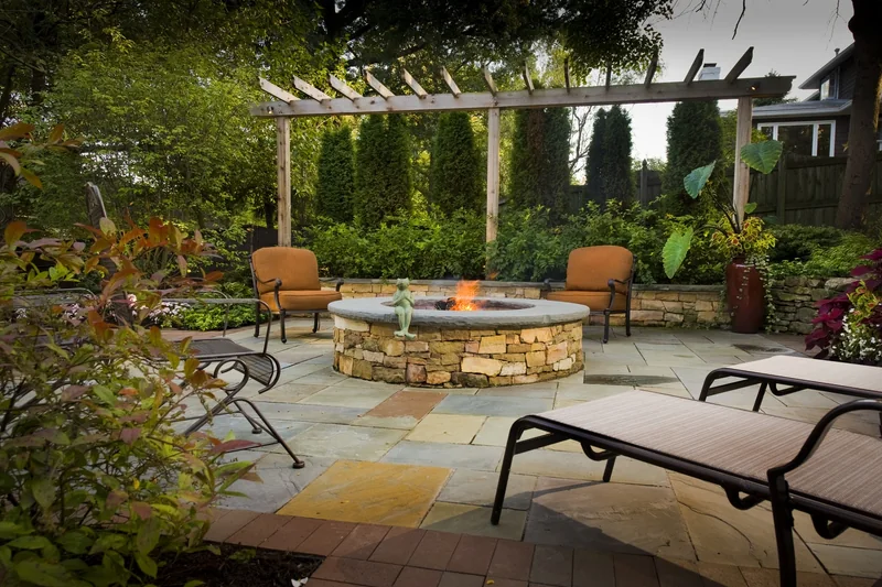 Stone fire pit with seating under a pergola