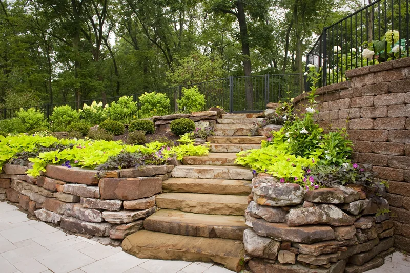 Layered block retaining wall supporting a planted slope